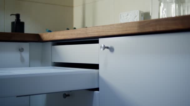 Unrecognizable womans hand closing cupboard drawer in kitchen indoors — Stock Video