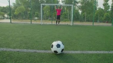 Futbolcu penaltıyı dışarı atarken futbol topunun yakın çekimi.