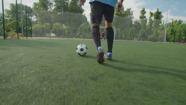 Egy közeli kép a focista lábairól. Foci trükkök, csöpög a pályán — Stock videók