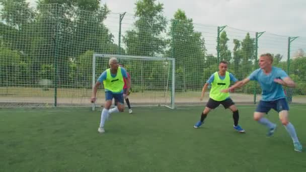 Jugadores de fútbol luchando por la posición en el campo de fútbol al amanecer — Vídeo de stock