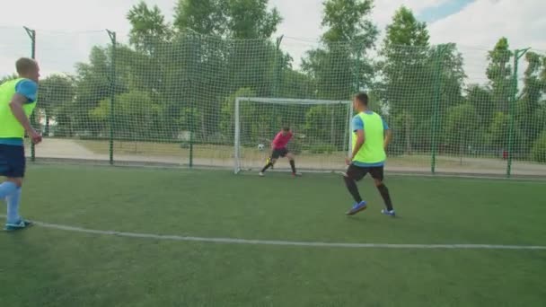 Voetballer in sportkleding neemt strafschop, scoort doelpunt buiten — Stockvideo