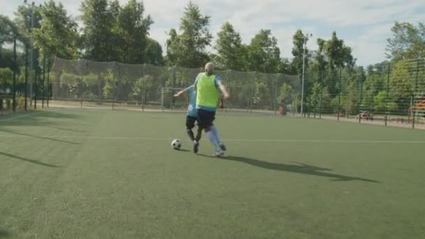 Voetbalverdediger het plegen van een overtreding tegen voetbal staker op het veld — Stockvideo