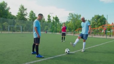 Futbol hakemi sahadaki futbol takımının maçına başlamak için ıslık çalıyor.