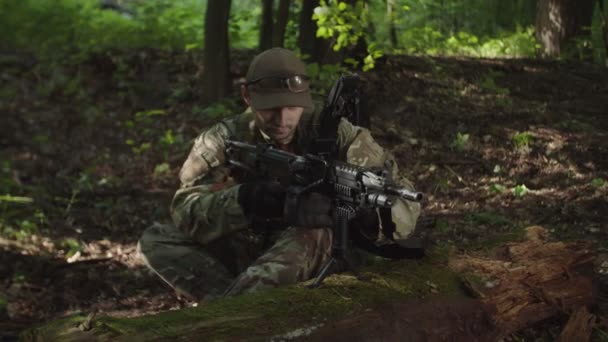 Militar en camuflaje recargando ametralladora con caja de municiones — Vídeo de stock