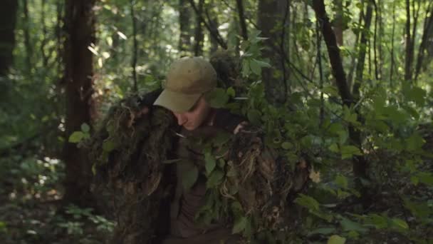Militär krypskytt i kamouflage redo att skjuta i skogen i gryningen — Stockvideo