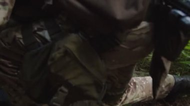Yaralı askerin bacağına turnike uygulayan sıhhiyeci yakın plan.