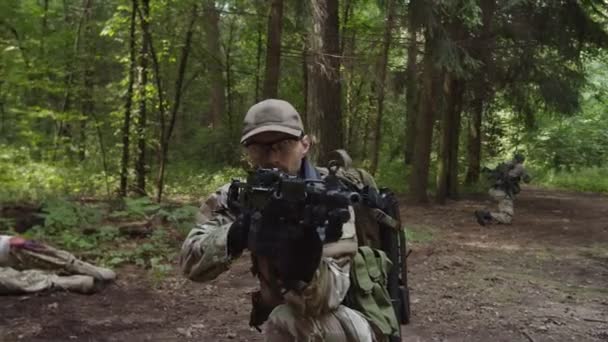 Soldaat met machinegeweer ter dekking van militaire eenheid in evacuatiepunt — Stockvideo