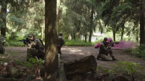 Seitenansicht von Soldaten, die mit verwundeten Soldaten auf die Evakuierung warten — Stockvideo