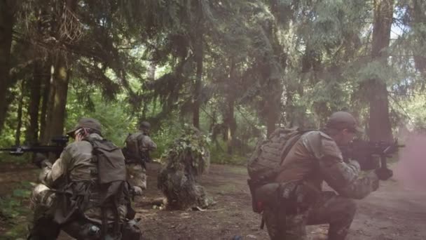 Разведывательный отряд прикрывает раненого солдата, ждет эвакуации — стоковое видео
