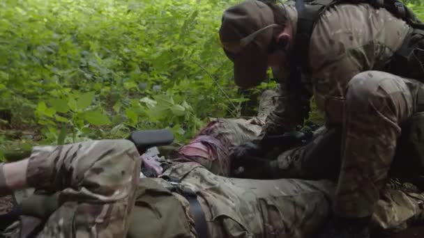 Médico de combate aplicando kit de primeiros socorros, fornecendo tratamento de emergência — Vídeo de Stock