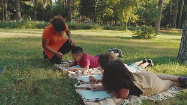 Profesor tutoría alumno que espiando en la hoja de examen de compañero de clase al aire libre — Vídeos de Stock