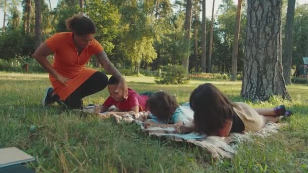 Teacher applying pedagogical methods in playful way to pupil outdoors — Stock Video