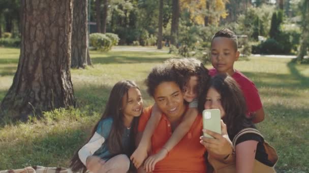 Basisleerlingen en schooljuf fotograferen in openbaar park — Stockvideo