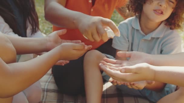 Okouzlující učitel použití ruční dezinfekci pro školní děti venku — Stock video