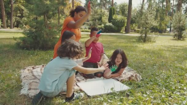 Creatividad escolar durante la clase al aire libre en el parque público — Vídeo de stock