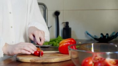 Mutfak tezgahında biber dilimleyen kadın.