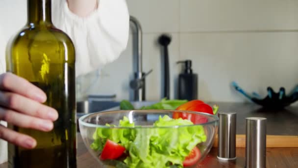 Woman in home clothes dressing vegetable salad with olive oil indoors — Stock Video