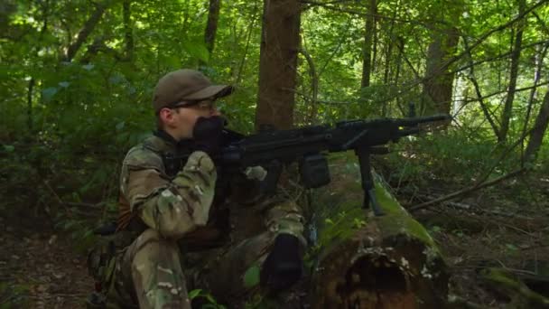 Охранник стрелок наблюдает поле зрения в лесу, курит, отдыхает — стоковое видео