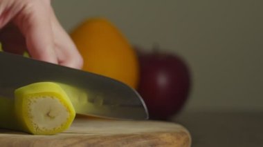Yakın plan mutfak bıçağı, kapalı alanda muz kesme.