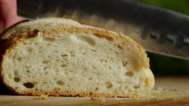 Close-up of hand with kitchen knife slicing crispbread indoors — Stock Video