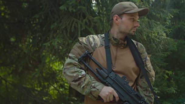 Retrato de soldado masculino con ametralladora mirando al aire libre — Vídeo de stock