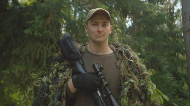 Porträt eines jungen Soldaten im Ghillie-Anzug mit Scharfschützengewehr im Freien — Stockvideo