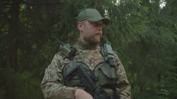 Στρατιωτικός άνδρας με εξοπλισμό μάχης χαμογελώντας με αυτοϊκανοποίηση σε εξωτερικούς χώρους — Αρχείο Βίντεο