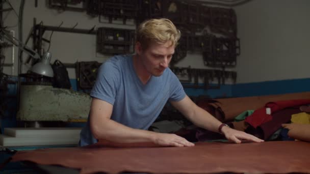 Мастерская квалифицированный работник проверки качества кожаного листа в помещении — стоковое видео