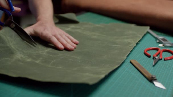 Kleersnijden canvas stof met schaar langs gesneden lijnen op werktafel binnen — Stockvideo