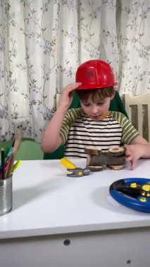 İlkokul çağındaki neşeli genç bir çocuk kapalı bir masada otururken oyuncaklarla oynuyor. Enerji ve hayal gücüyle dolu, rahat, güvenli ve yaratıcı bir ortamda eğleniyor.. 