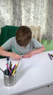 Evde kalemlerle resim çizen sevimli bir okul çocuğu. Yaratıcı bir işle uğraşıyor. Hobisine odaklanmış, evde boş vakit geçirirken hayal gücü ve sanatsal beceriler geliştiriyor.. 