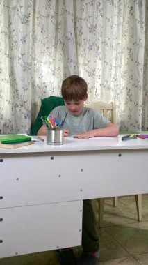 Evde kalemlerle resim çizen sevimli bir okul çocuğu. Yaratıcı bir işle uğraşıyor. Hobisine odaklanmış, evde boş vakit geçirirken hayal gücü ve sanatsal beceriler geliştiriyor.. 