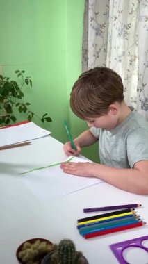 Evde kalemlerle resim çizen sevimli bir okul çocuğu. Yaratıcı bir işle uğraşıyor. Hobisine odaklanmış, evde boş vakit geçirirken hayal gücü ve sanatsal beceriler geliştiriyor.. 