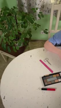 Genç kız makyaj yapmayı evde öğreniyor, kozmetik ürünlerini merakla ve özenle kullanıyor. Genç yaşta güzelliği ve kendine bakımı keşfetti, rahat ve tanıdık bir ortamda pratik yapıyor.. 