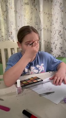 Genç kız makyaj yapmayı evde öğreniyor, kozmetik ürünlerini merakla ve özenle kullanıyor. Genç yaşta güzelliği ve kendine bakımı keşfetti, rahat ve tanıdık bir ortamda pratik yapıyor.. 