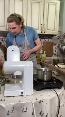 Önlüklü genç baba ve küçük kızı mutfakta birlikte yemek pişiriyorlar. Aile tatillerini paylaşırlar, yemek hazırlama ve sıcak bir yuva ortamında eğlenceli etkileşimlerle eğlenirler.