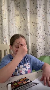 Genç kız makyaj yapmayı evde öğreniyor, kozmetik ürünlerini merakla ve özenle kullanıyor. Genç yaşta güzelliği ve kendine bakımı keşfetti, rahat ve tanıdık bir ortamda pratik yapıyor..