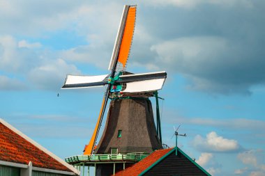 Yel değirmenleri mavi gökyüzü ile vuruldu ve yel değirmeni köyünde bulutlar