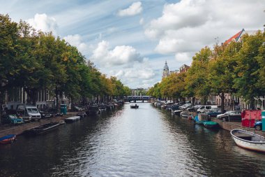 Karmaşık kanalları olan Amsterdam 'ın yüzü, mavi gökyüzü, beyaz bulutlar, yeşil ağaçlar