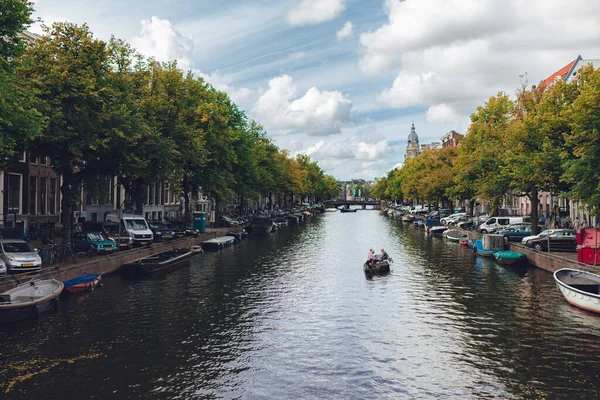 Karmaşık kanalları olan Amsterdam 'ın yüzü, mavi gökyüzü, beyaz bulutlar, yeşil ağaçlar