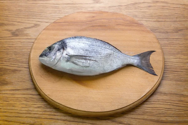 Dorado pescado en un tablero de madera vew superior —  Fotos de Stock