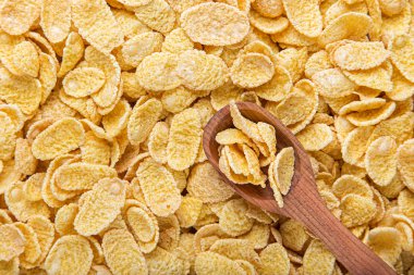 Bir tahta kaşık Mısır gevreği arka plan üzerinde içinde Mısır gevreği.