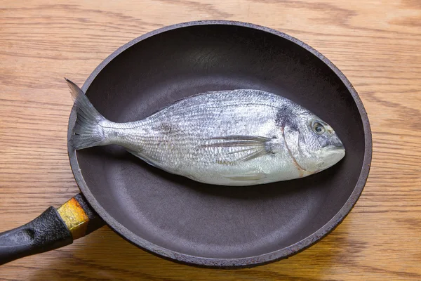 dorado fish in a frying pan,  healthy food. top vew