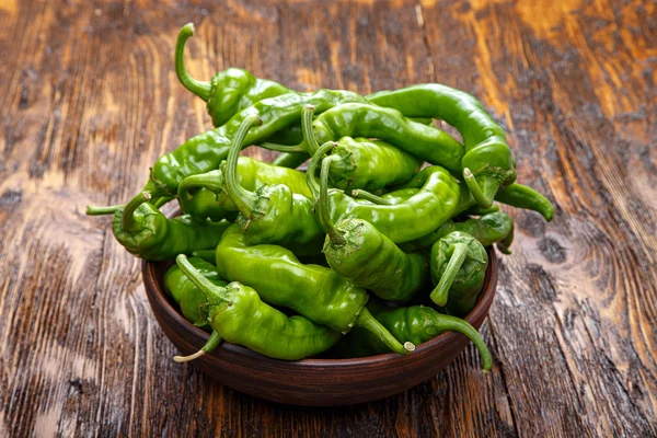 Hot green peppers in clay plate — Stock Photo, Image