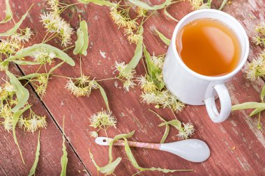 Linden çay bir fincan ahşap arka plan üzerinde.