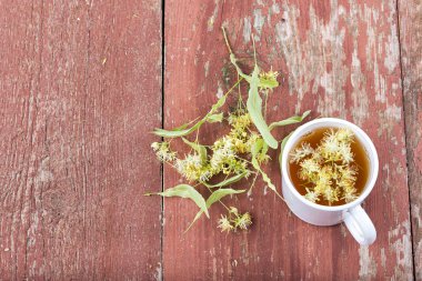 Linden çay bir fincan ahşap arka plan üzerinde.
