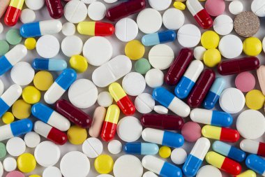 Beyaz arka planda bir sürü farklı hap var. Tıbbi konsept. Çeşitli hastalık tehdidi kavramı. Üst görünüm.