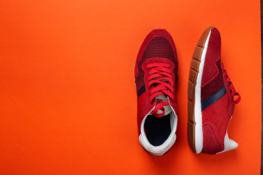 Renkli arka planda bir çift şık kırmızı spor ayakkabı, metin için boşluk. Üst görünüm.