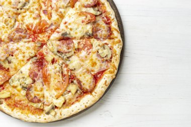 Domatesli, mozarellalı ve beyaz ahşap arka planda pastırmalı lezzetli, sade pizza. Metin için boşluk.