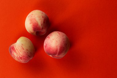 Turuncu arka planda taze, olgun şeftaliler. Lezzetli ve sağlıklı meyveler. Sağlıklı gıda konsepti.